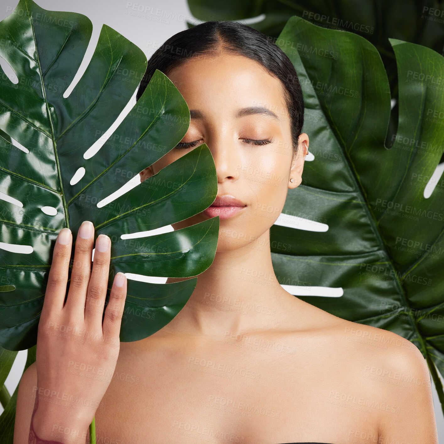 Buy stock photo Woman, leaves and sustainable skincare in studio with wellness, self care or organic treatment. Person, monstera plant and glow with natural cosmetics, dermatology or beauty on white background.