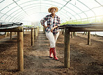 Full body of young farmer in a garden. Portrait of a proud farmer in her greenhouse. Happy african american farmer. Young farmer standing in her garden. Farm employee standing in a nursery