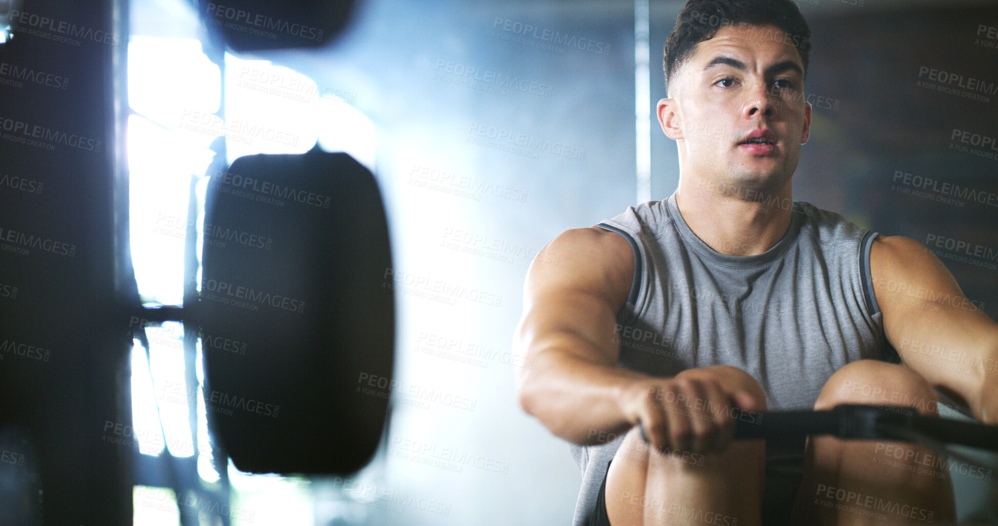 Buy stock photo Fitness, workout or man in gym with rowing, power or strength exercise for body improvement. Serious, core endurance or athlete with machine, intense training or challenge for muscle development.