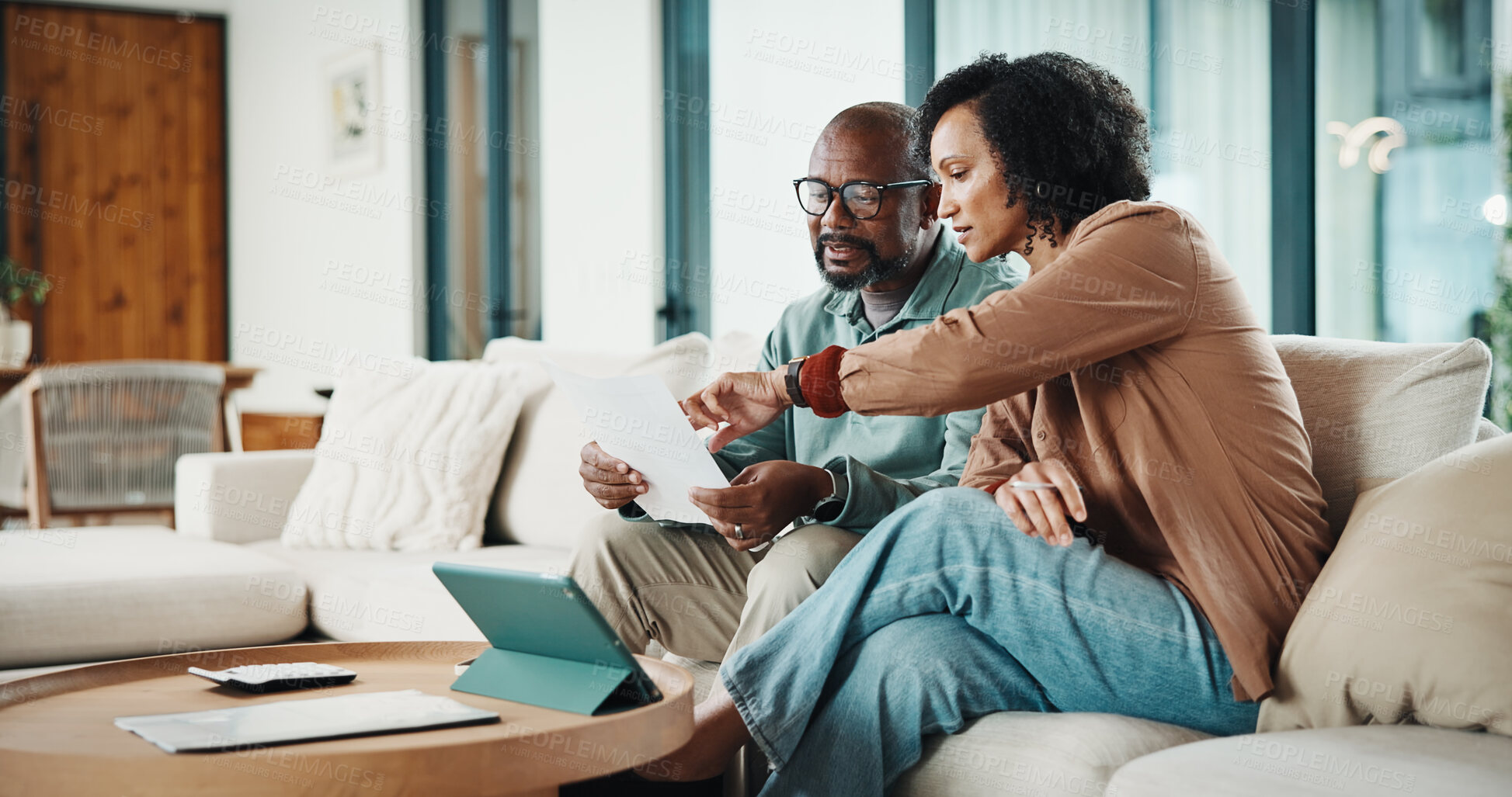 Buy stock photo Document, home and couple with financial feedback, insurance policy or tax review with tablet. African man, mature woman and savings discussion for debt planning, paperwork or bills with tech on sofa