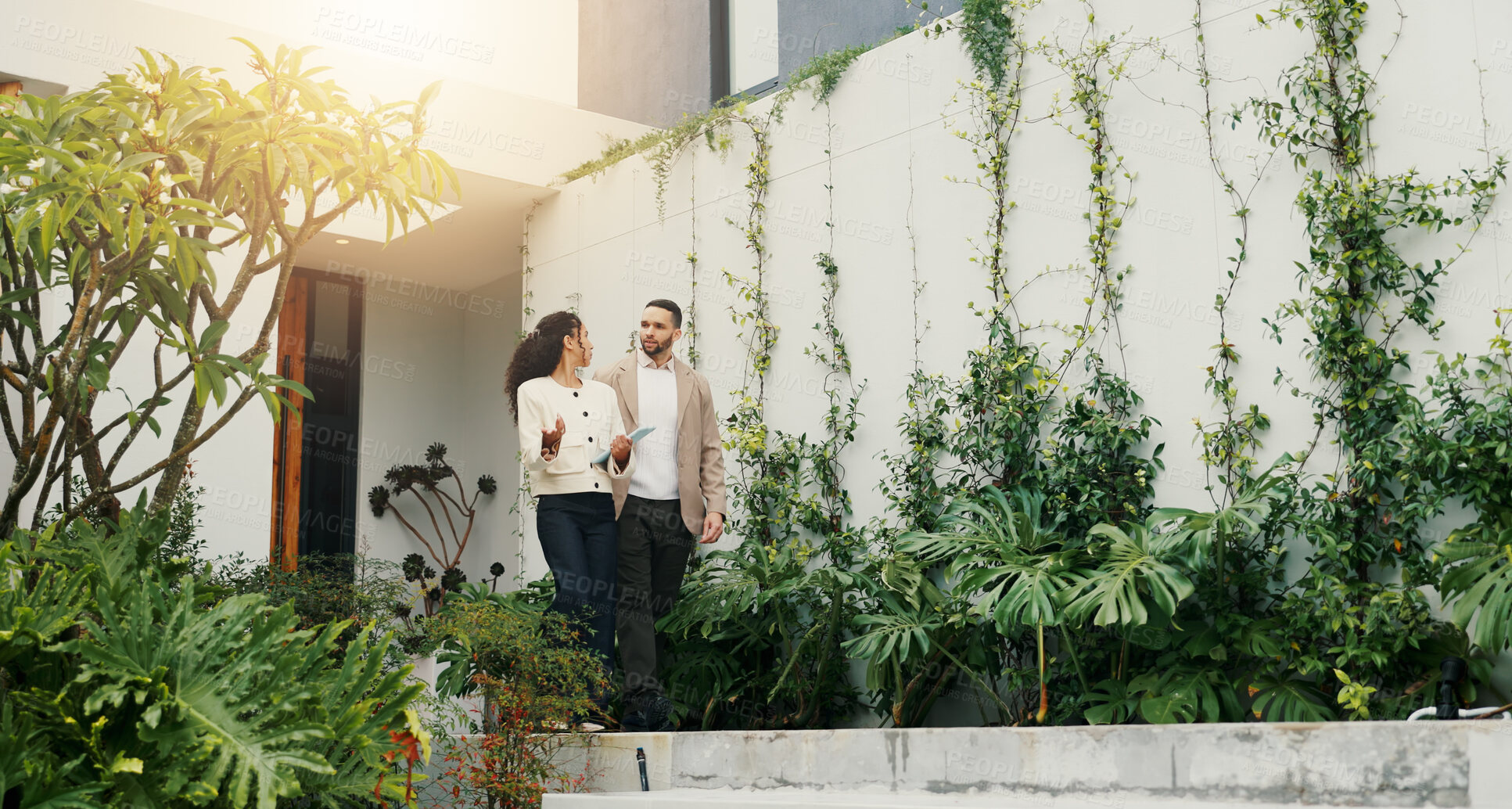 Buy stock photo Explain, realtor and view with client walking for home investment or property tour. Listing, mortgage and rental apartment with estate agent woman speaking to man outdoor for advice or consulting