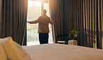 Man, sunlight and open curtain in hotel room for window view to start day, fresh air and relax. Business trip, accommodation and person at lodge with luggage, back and bedroom for hospitality 