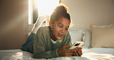 Buy stock photo Relax, reading and girl with phone in bedroom, social media app and connection for browsing internet. Smile, rest and child with online platform for message, watch video and streaming movie in home