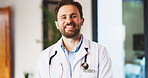 Man, doctor and smile with portrait at clinic with confidence, pride and job with healthcare services. Person, medical professional and pediatrician in hallway for wellness at hospital in Portugal