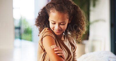 Buy stock photo Girl, touch and plaster for vaccine in home with flu shot, healthcare and smile in bedroom. Kid, bandage and happy with injection for immune system boost for virus, germs or medicine at apartment