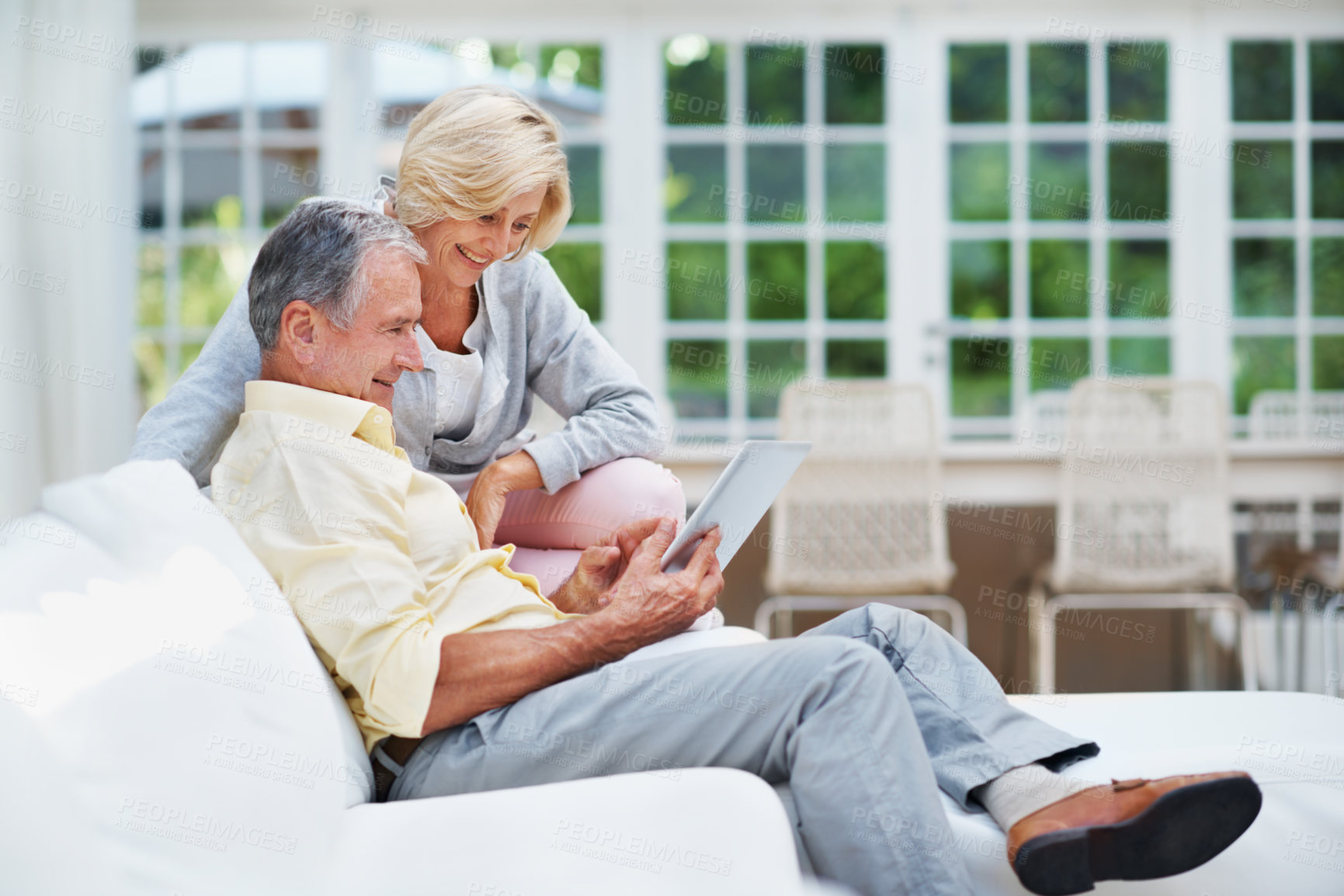Buy stock photo Smile, tablet and watch with old couple on sofa for retirement home review, planning and support. Senior living research, discussion and connection with elderly man and woman in lounge of house