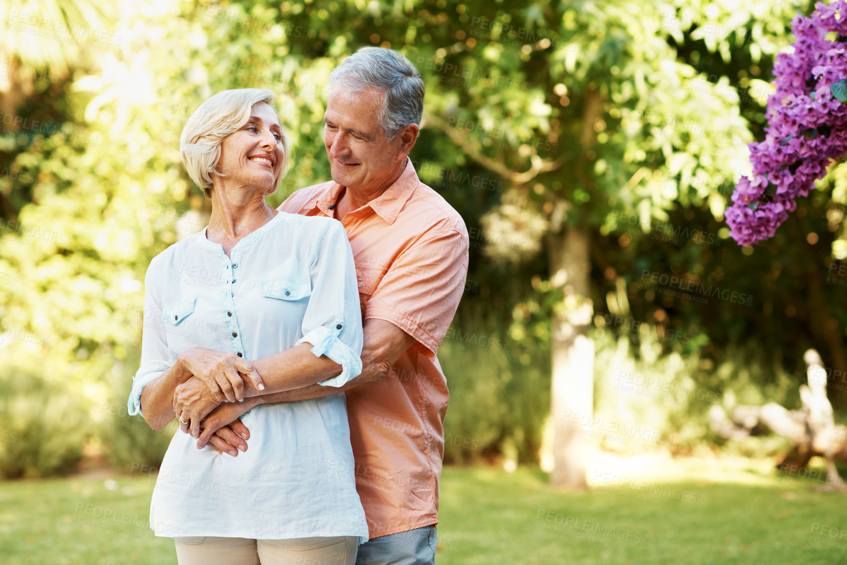Buy stock photo Senior, couple and hug in nature for bonding, love and affection for relationship wellness in marriage. Woman, man and happy in park or garden, smile and care with support together in retirement