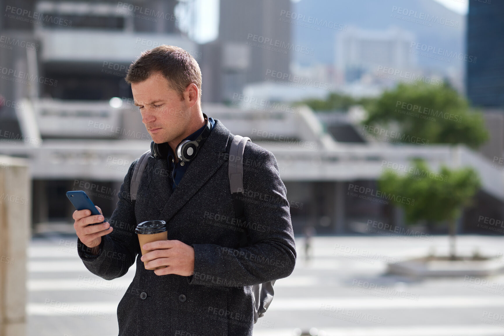 Buy stock photo Businessman, travel and texting with phone in city, online and reading investment update on website. Serious, asset manager and person with coffee on street, commuting and communication on mobile