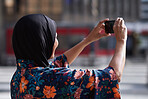 Muslim woman taking photo using smartphone in city tourist photographing urban travel with mobile phone camera wearing hijab headscarf
