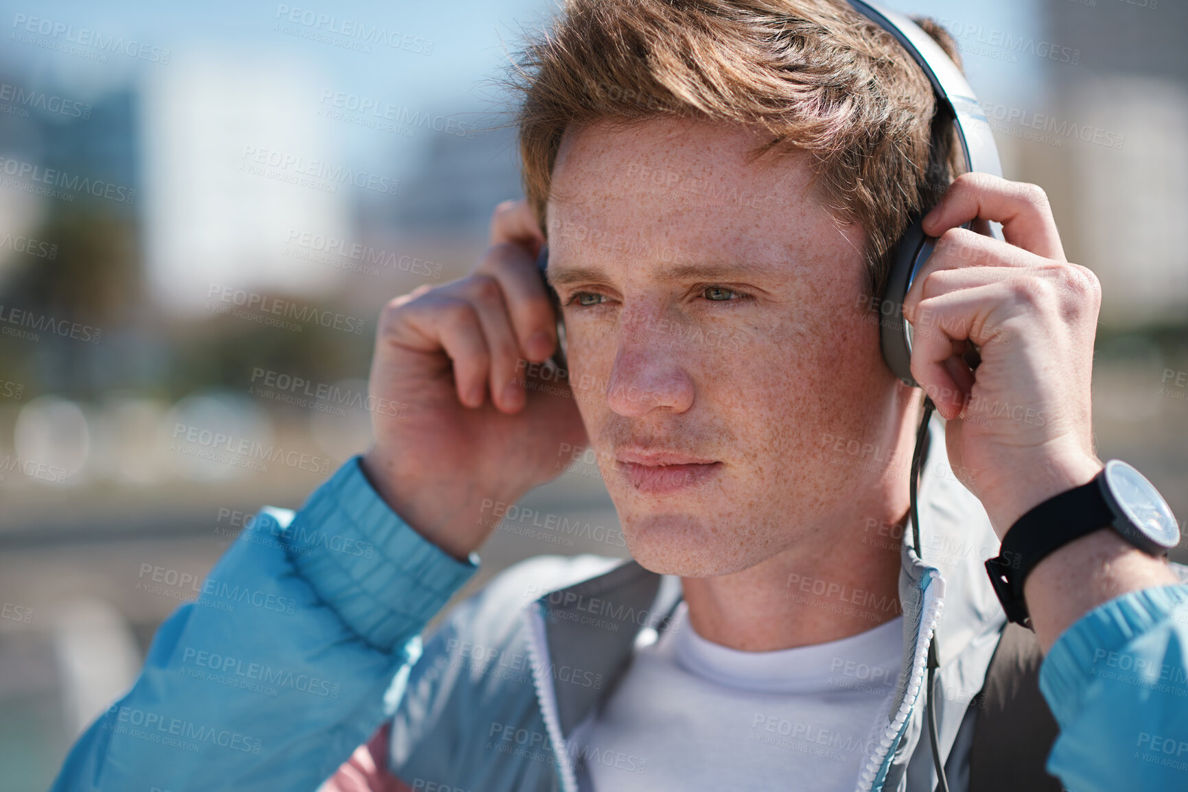 Buy stock photo Headphones, beach and man on holiday with travel for listening to music, playlist or radio. Promenade, audio tech and male person streaming album by ocean on summer vacation, getaway or weekend trip.