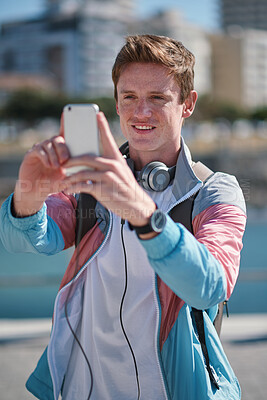 Buy stock photo Man, travel and picture with phone in city for sightseeing, capture moment or destination. Male person, tourist or traveler with smile or smartphone for photography or social media post in urban town