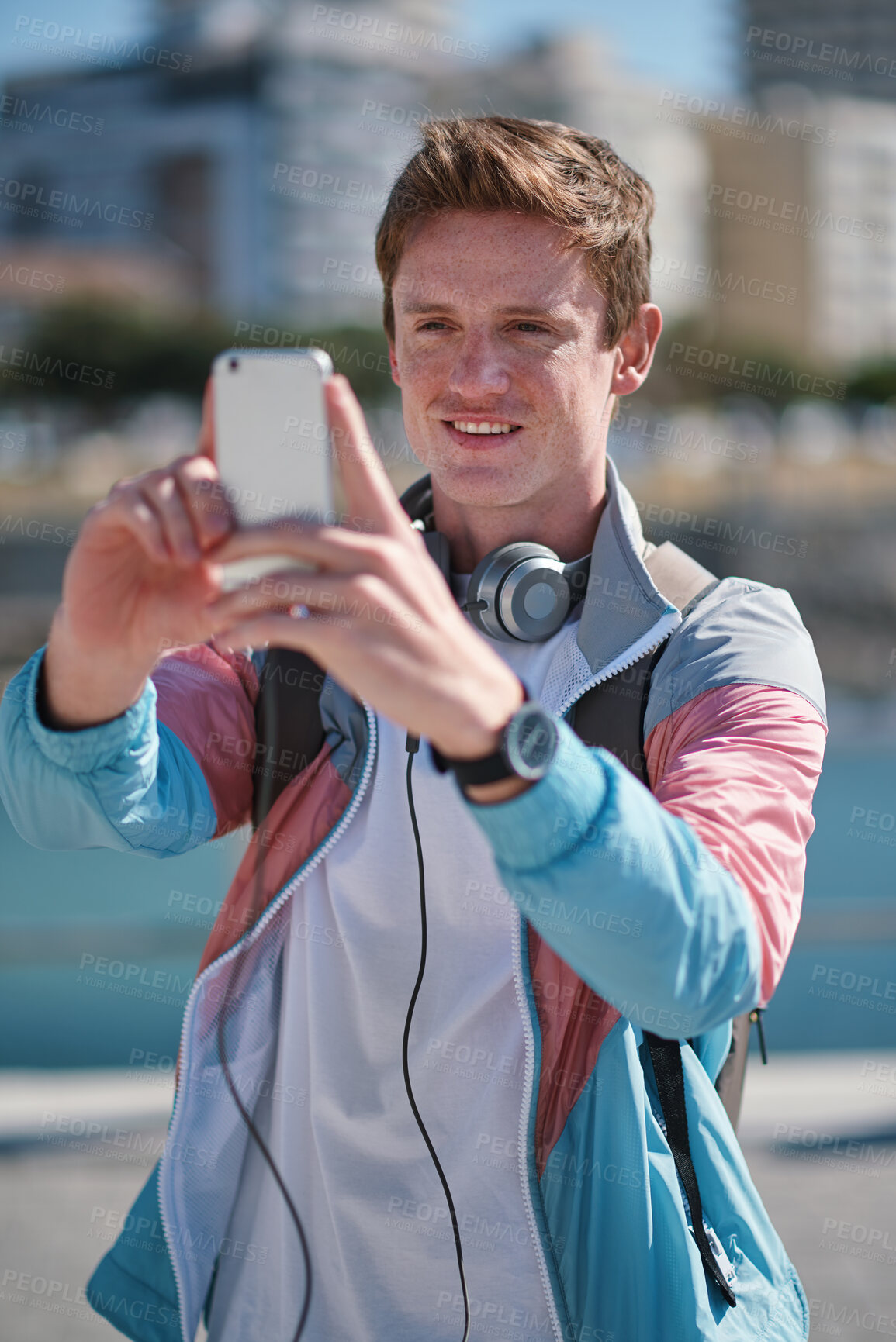 Buy stock photo Man, travel and picture with phone in city for sightseeing, capture moment or destination. Male person, tourist or traveler with smile or smartphone for photography or social media post in urban town