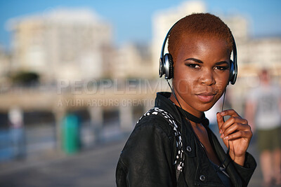 Buy stock photo Headphones, beach and portrait of black woman on holiday with listening to music, playlist or radio. Promenade, audio tech and person streaming album by ocean on vacation, getaway or weekend trip.