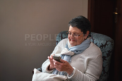 Buy stock photo Smile, relax and old woman in home with phone, social media and browsing website for weekend break. Happy, senior person and texting at house with mobile, online bingo and calm morning on retirement