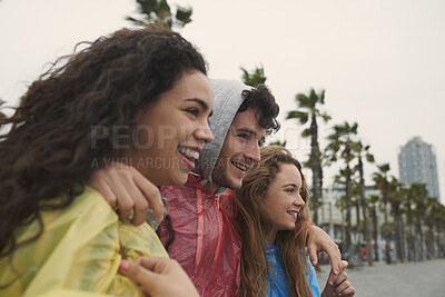 Buy stock photo Happy, hug and group of friends by beach in winter on holiday, getaway or weekend trip together. Smile, outdoor and people with rain coat on vacation for bonding, connection or fun in cold weather.