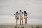 Three friends celebrate carefree lifestyle arms raised in happiness on vacation