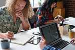 business students brainstorming working on college project sitting at table with young man writing notes