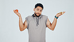 Portrait, apple and man with pizza, decision and weight management for fitness goals. Confused, food or athlete on studio background with shrug, healthy eating or nutrition selection in balanced diet