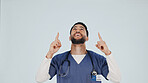 Doctor, pointing and happy man in studio for advertising, option or selection on a white background. Male person, healthcare worker or smile with presentation for marketing, choice or health tip