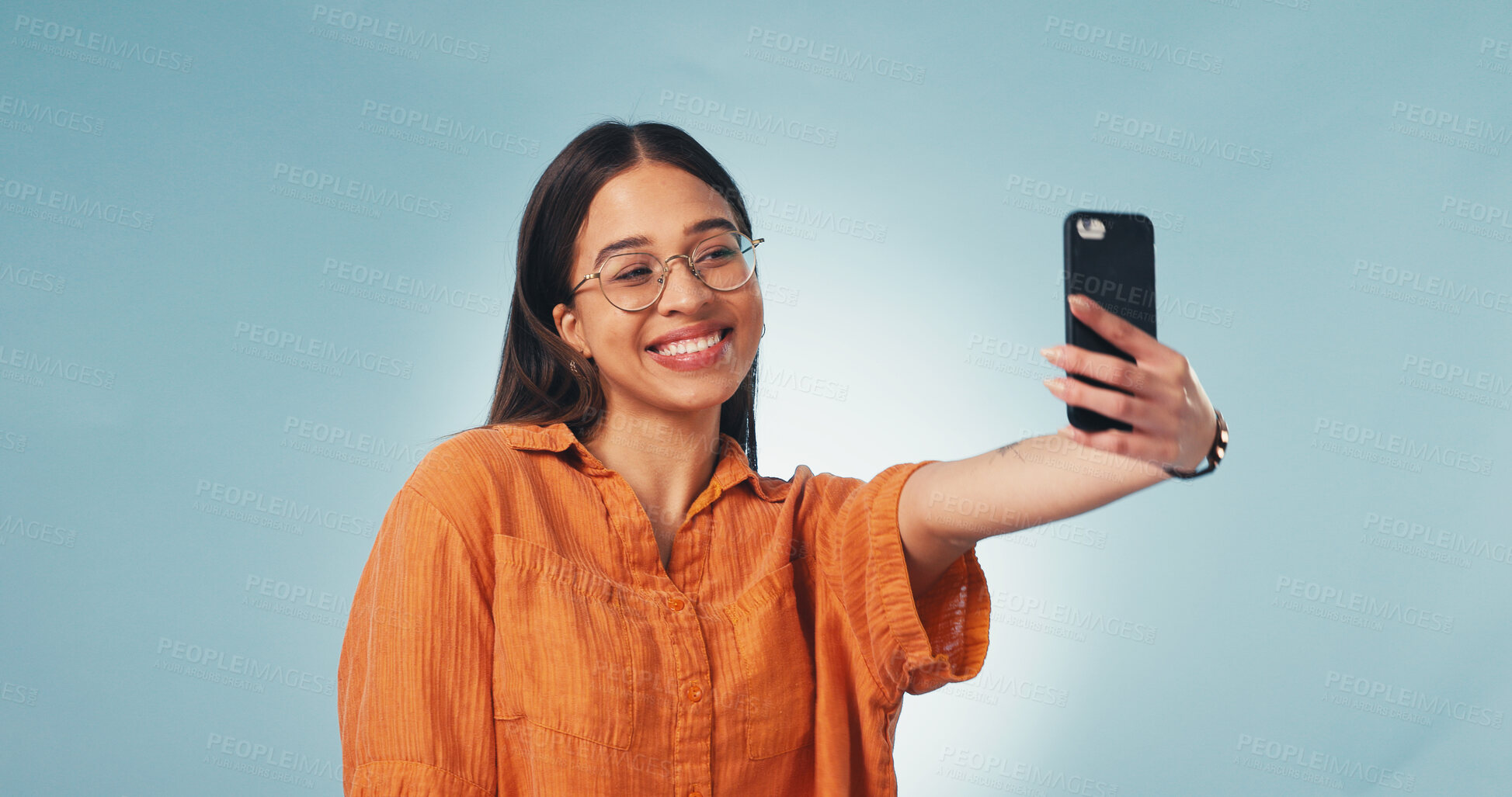 Buy stock photo Happy, woman and student with selfie in studio for memory, social media or college blog. Smile, glasses and female person with photography picture for university by blue background with space.