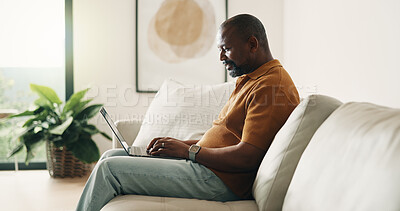 Buy stock photo Laptop, typing and black man on sofa with remote work, planning or creativity for copywriting project. Freelancer, mature person and online in home with computer, research or copywriter for campaign.