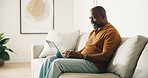 Laptop, typing and black man on couch with remote work, planning or creativity for copywriting project. Freelancer, mature person and online in home with computer, research or copywriter for campaign