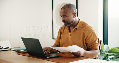 Buy stock photo Man, paperwork and remote work in house with laptop, typing ESG report and sustainability audit. Mature, black person or contract worker in home with computer, document and environmentalist research.