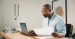 Laptop, document and black man in home office with remote work, admin or research for tax preparation. Freelancer, mature person and computer in house with glasses, paperwork and wealth management.