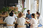 Creative, people and meeting in cafe with remote work, brainstorming and discussion for advertising. Freelancer, team collaboration and talk in coffee shop with marketing project, planning or update.