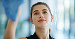 Woman, cleaning and window with wipe in office for hygiene, disinfection or maintenance. Female person, cleaner or glass surface with reflection or detergent for dirt, bacteria or germ removal