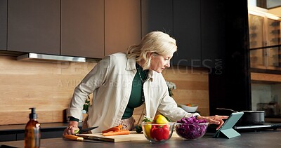 Buy stock photo Woman, cooking and vegetables in home with tablet, online recipe and meal prep for healthy food. Mature person, digital or tutorial in kitchen with ingredients, culinary skills and research for salad