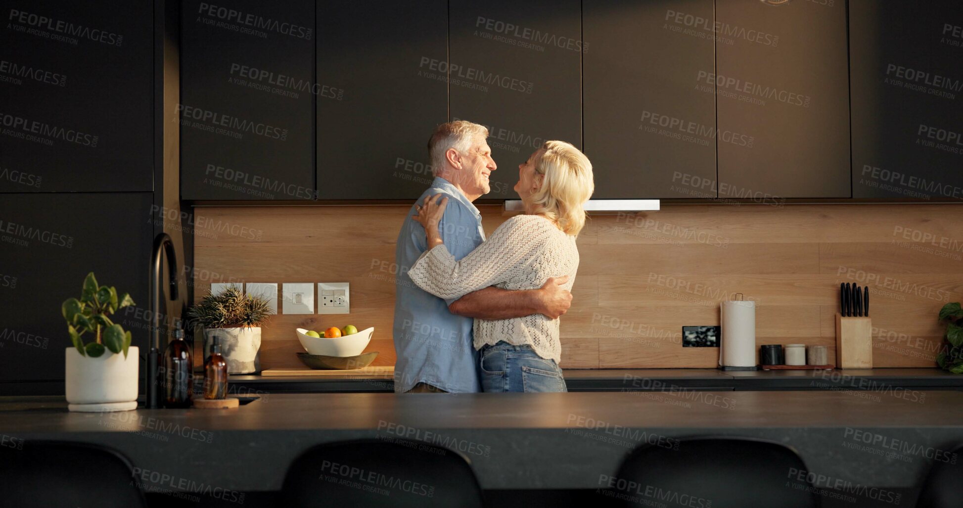 Buy stock photo Smile, hug and old couple in home for support, comfort or bonding together in kitchen. Love, commitment and elderly man with woman for connection with marriage, anniversary and embrace in apartment