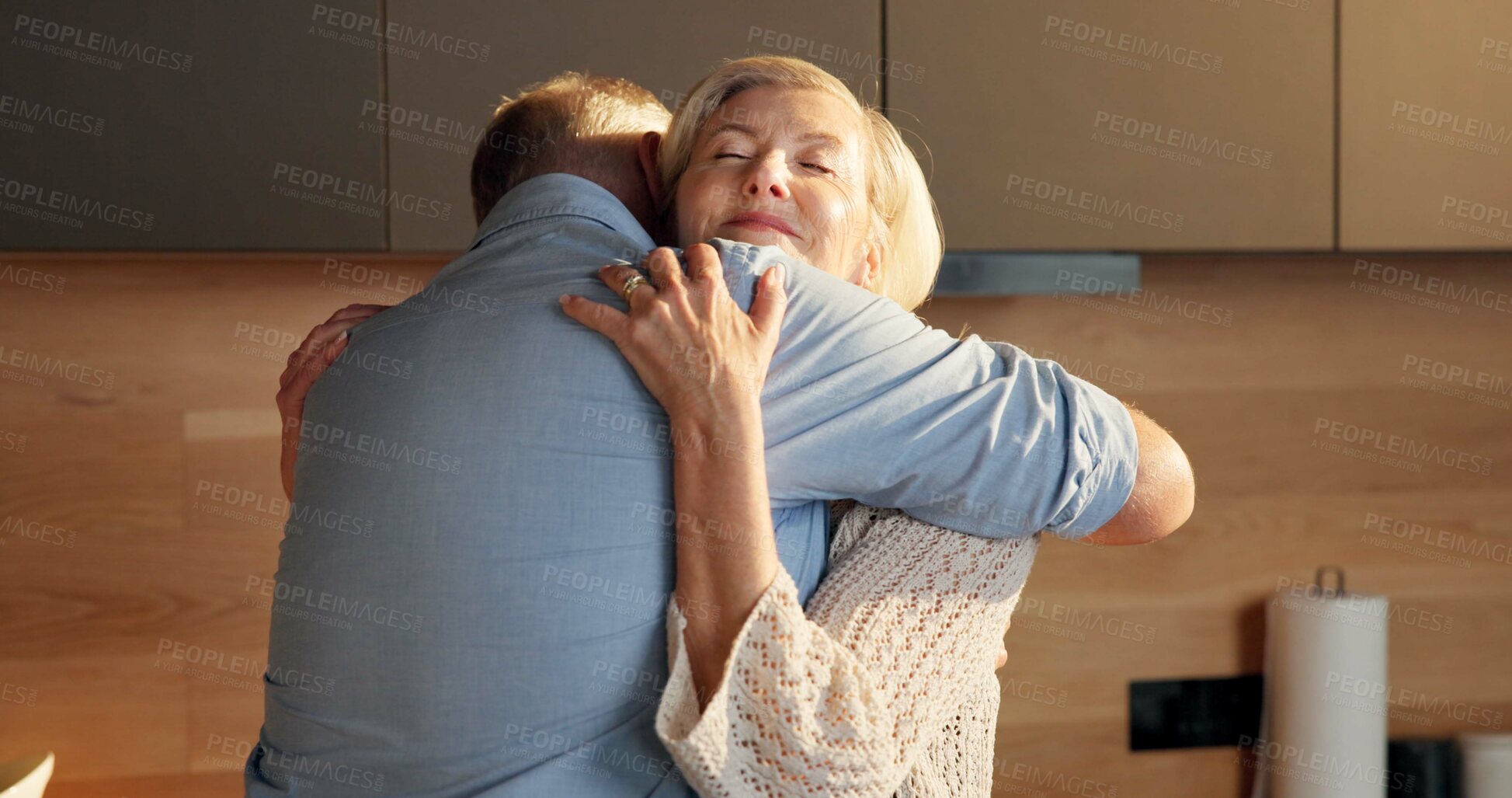 Buy stock photo Smile, hug and elderly couple in home for support, comfort or bonding together in kitchen. Love, commitment and senior people for connection with marriage, anniversary and embrace in apartment