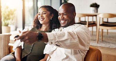 Buy stock photo Couple, relax and watching tv in living room with remote, movie entertainment and bonding together. Married, African people smile and change channel in home with tech, streaming service and series.
