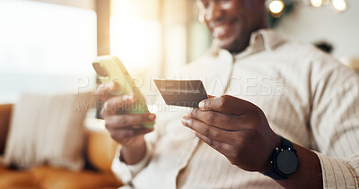Buy stock photo Hands, man and phone with credit card in home for online payment, remote shopping or banking app. Male person, shopper or smile with debit, lens flare or smartphone on sofa for ecommerce in house