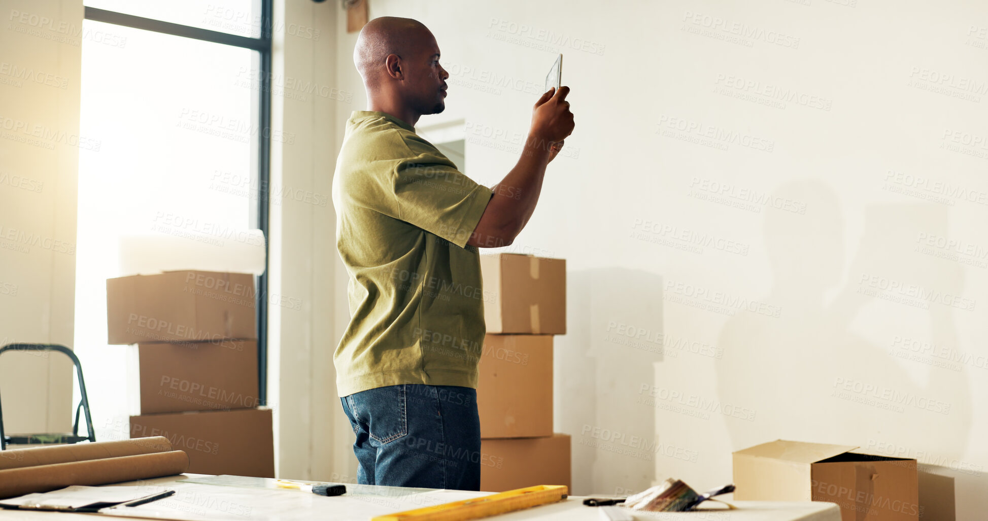 Buy stock photo Man, renovation and picture in new home with tablet, app and digital render for interior design plan. Black person, tech and photography in house with space, website and online tools for remodeling.