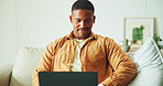 Laptop, relax and man on sofa in home for remote work on software development project in living room. Smile, computer and male frontend engineer with online programming for freelance career in house.