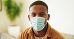 Face mask, portrait and virus with black man in home living room for prevention of infection. Compliance, protection and safety with person on sofa in apartment for healthcare or medical regulations