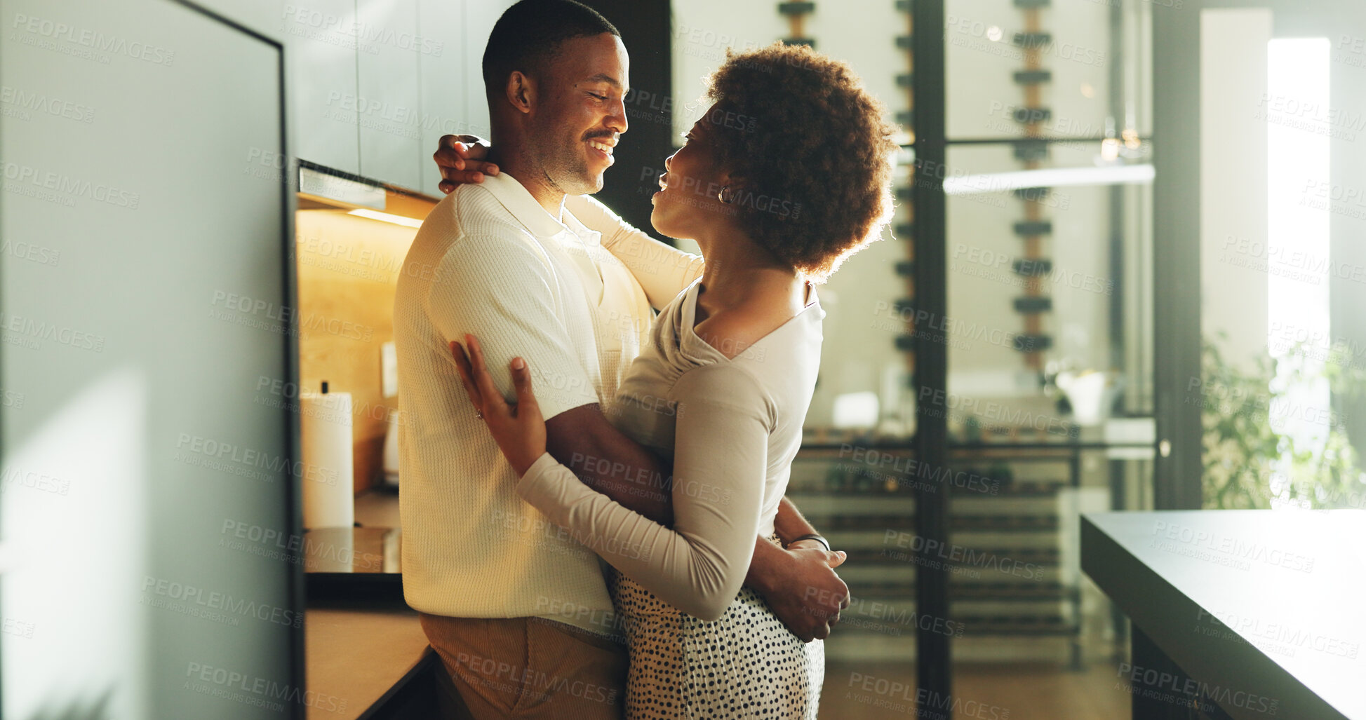 Buy stock photo Happy, couple and hug in kitchen with connection, bonding together and relax on weekend break in home. Married black people, smile and embrace in house with relationship commitment, loyalty and care.