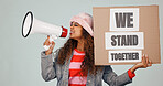Woman, billboard and protest with megaphone in studio for verbal warning, announcement or alert. Female person, activist or feminist with loudspeaker, bullhorn or poster for rights or unity together