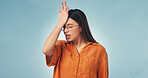 Woman, stress and studio with mistake for brain fog, regret or bad news on a blue background. Upset, female person or forget with disappointment for schedule delay, poor reminder or memory loss