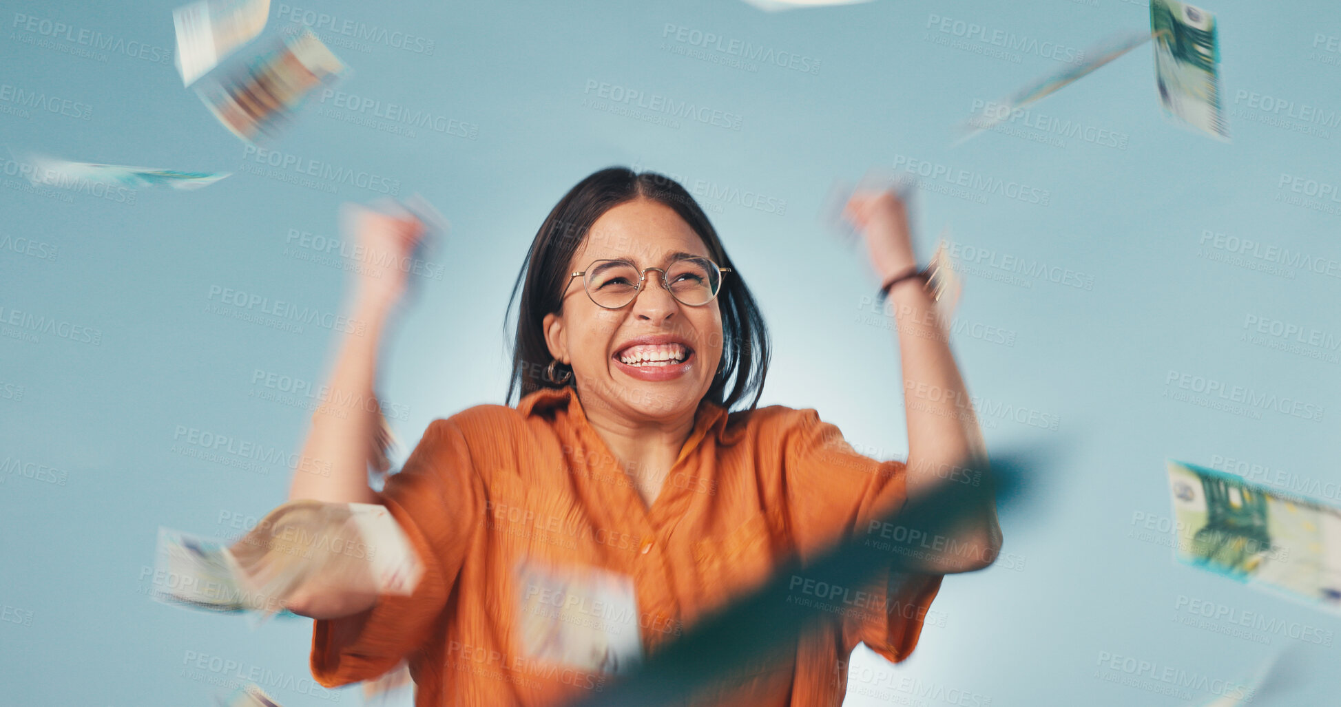 Buy stock photo Excited, winner and woman in studio with money rain, lottery success and giveaway prize. Happy, celebration and person with cash for winning competition, promotion and income bonus on blue background