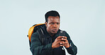 Travel, photography and man in studio with phone, backpack or tourist memories for holiday adventure. Space, black person and tech for vacation picture, social media post and trip on blue background.