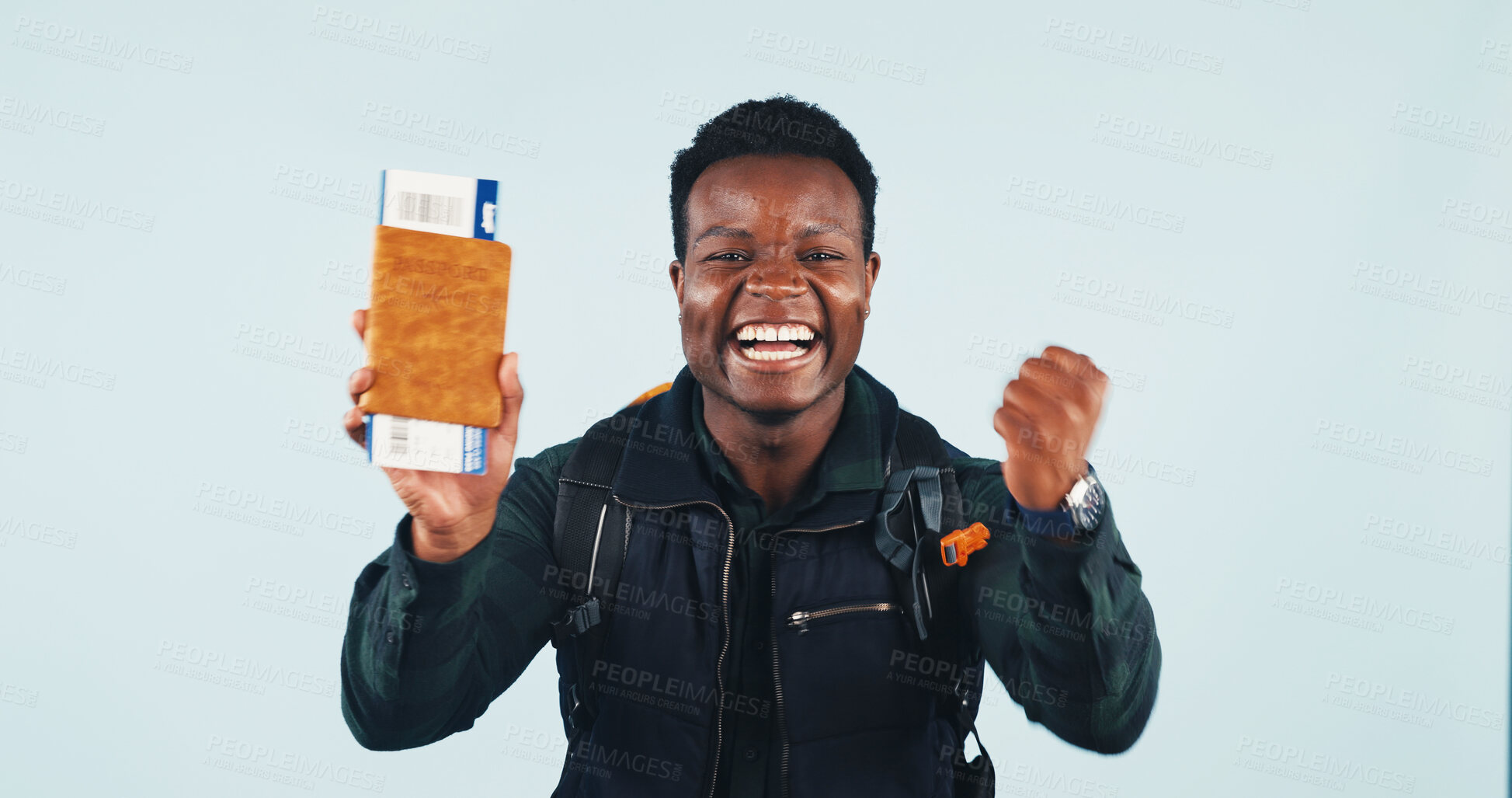 Buy stock photo Portrait, man and celebration in studio with passport, flight ticket and VISA approval for vacation. Excited, black person and fist pump with ID document, tourist travel or holiday on blue background