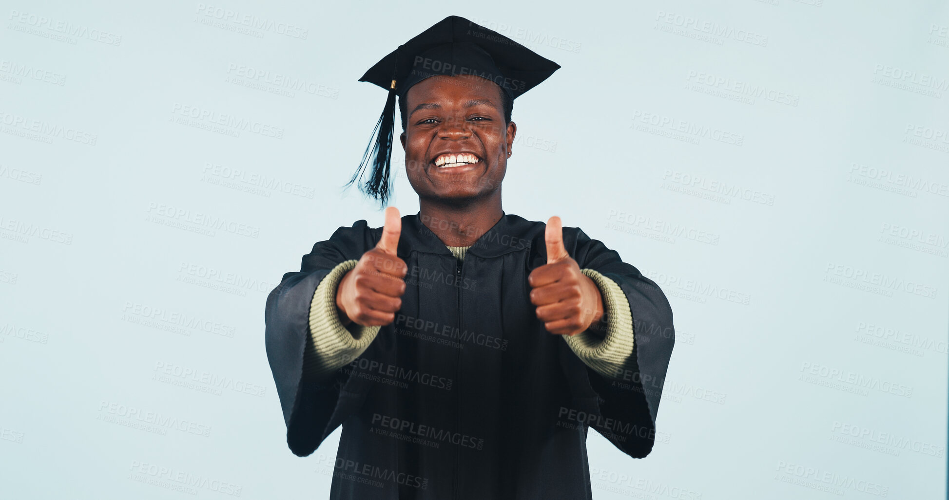 Buy stock photo Graduation, portrait or black man with thumbs up in studio for education on a blue background. Male person, student or happy graduate with smile, like emoji or yes for academic success or achievement