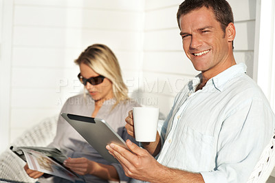 Buy stock photo Couple, tablet and man on patio with coffee, social media and browsing website for weekend. Portrait, people and beverage at house with digital, calm morning and reading magazine for information