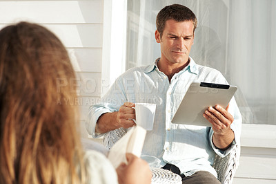 Buy stock photo Man, relax and coffee on patio with tablet, social media and browsing website for weekend break. Terrace, people and beverage at house with digital, morning news and comfortable for streaming movies