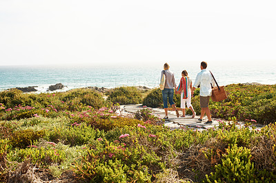 Buy stock photo Back, travel and love with family at beach for summer vacation, bonding and tropical adventure. Holiday getaway, care and picnic basket with parents and child on boardwalk for support and trust space
