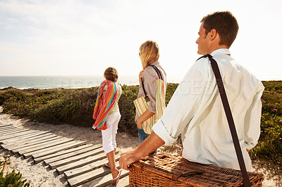 Buy stock photo Travel, boardwalk and love with family at beach for summer vacation, bonding and tropical adventure. Holiday getaway, care and picnic basket with parents and child outdoor for support and trip