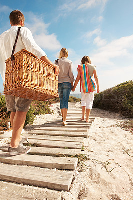 Buy stock photo Vacation, family and basket on coast path for summer getaway, weekend break and relationship. Back, child and parents with travel adventure on boardwalk for beach picnic, bonding and outing arrival